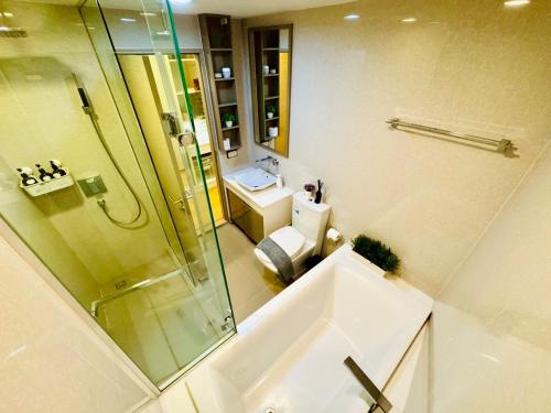 a bathroom with a shower and a toilet and a sink at Cozy Spacious 1BR 2Bed GardenView 500m BTS Thonglo, Samitivej, SKV49, Rooftop Pool, Fast 500mbps wifi in Bangkok