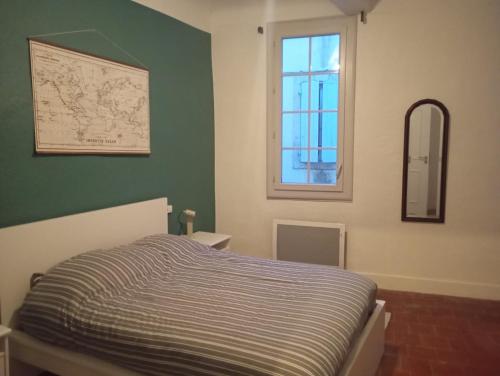 ein Schlafzimmer mit einem Bett und einem Fenster in der Unterkunft Maison atypique centre historique in Auch