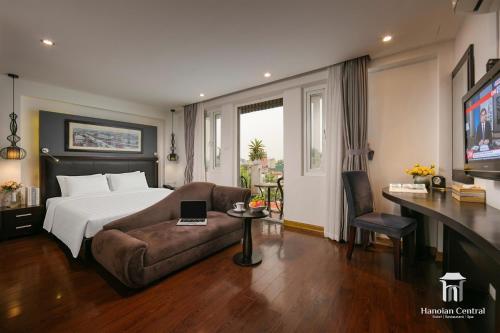 a hotel room with a bed and a couch at Hanoian Central Hotel & Spa in Hanoi