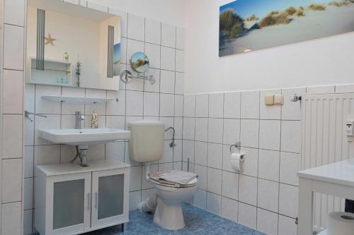 a bathroom with a toilet and a sink at Seebrise Apartments in Grömitz