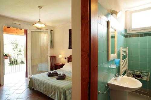 Habitación con baño con cama y lavabo. en Agriturismo Il Magicorto, en Cassola