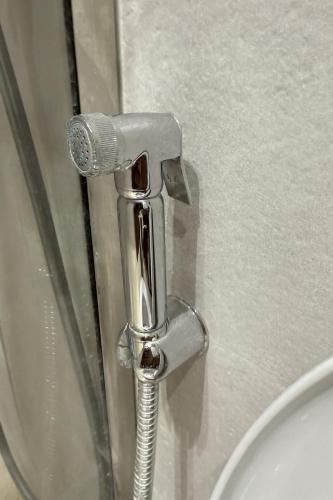 a bathroom with a toilet with a chrome handle at Cozy 2-bedroom studio in Casablanca