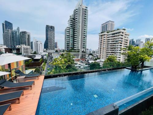 a large swimming pool on top of a building at Cozy Spacious 1BR 2Bed GardenView 500m BTS Thonglo, Samitivej, SKV49, Rooftop Pool, Fast 500mbps wifi in Bangkok