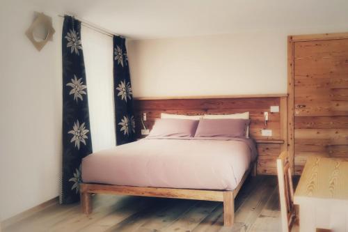 La Tornalla في أَويستا: غرفة نوم مع سرير مع اللوح الأمامي الخشبي