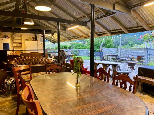 a wooden table with a vase of flowers on top of it at Mountain View Tilba Tilba - Glamping in Tilba Tilba