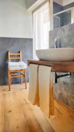 a bathroom with a sink and a chair at La Tornalla in Aosta