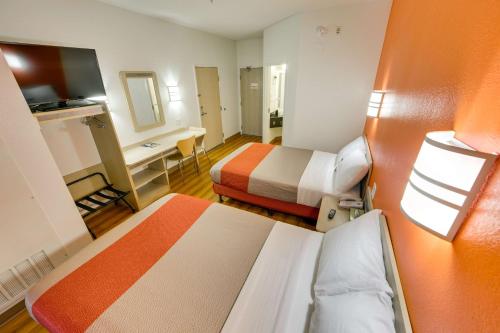 a small room with two beds and a desk at Motel 6-Brampton, ON - Toronto in Brampton