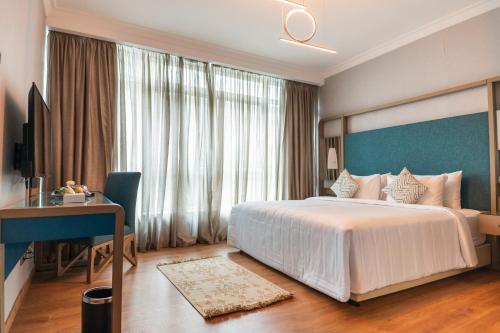 a bedroom with a large white bed and a desk and a window at Nile Suites Plaza Hotel Apartments in Cairo