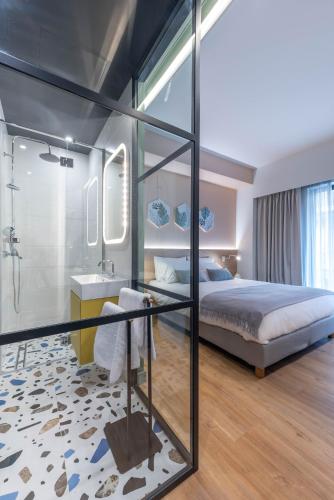 a bedroom with a bed and a shower and a sink at Corto Maltese Boutique in Athens