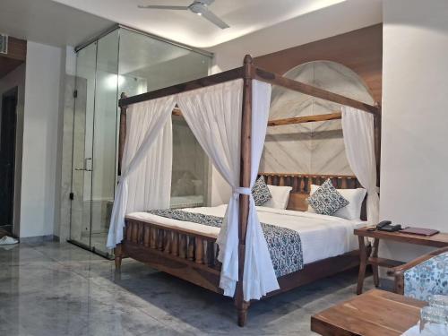 a bedroom with a canopy bed and a mirror at KING'SWAY Hotel & Resort in Dūngarpur