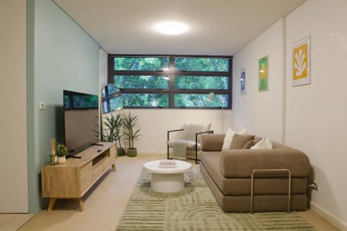a living room with a couch and a table at 1BR Waterfront Apartment in Barangaroo with Free Private Parking in Sydney