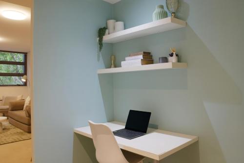 a room with a desk with a laptop on it at 1BR Waterfront Apartment in Barangaroo with Free Private Parking in Sydney