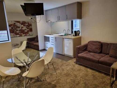 een woonkamer met een bank, een tafel en stoelen bij Melbourne ViVo in Melbourne
