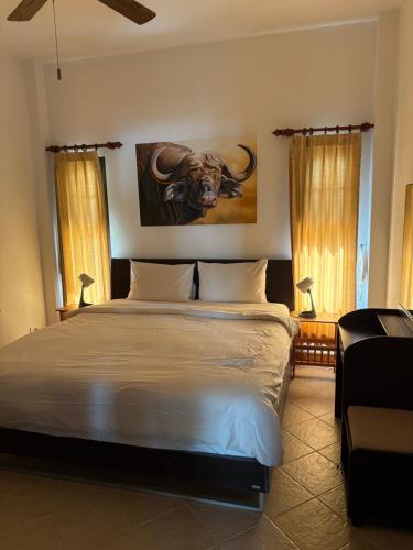 Paradis villa C8 في كو خو خاو: غرفة نوم بسرير مع لوحة على ثور