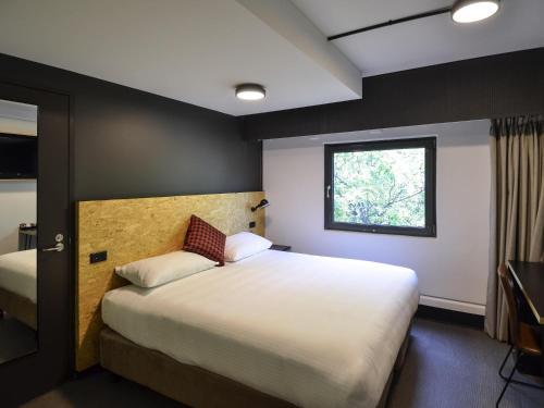 una camera da letto con un letto grande e una finestra di ibis budget Sydney East a Sydney