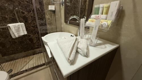 a bathroom with a white sink and a shower at Rojina Hotel in Amman