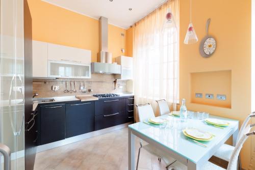 een keuken met een tafel en een eetkamer bij Hostdomus - Il Maestrale Apartment in Alassio
