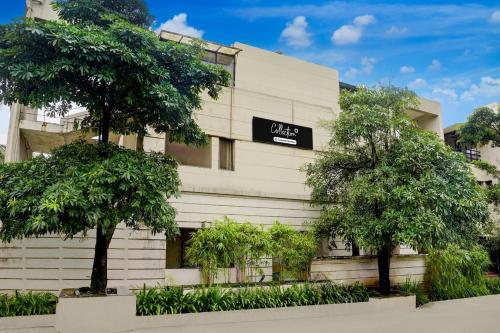 un edificio con árboles delante en Palette by CheckIn Igatpuri Formerly Bodh Valley Resort, en Igatpuri