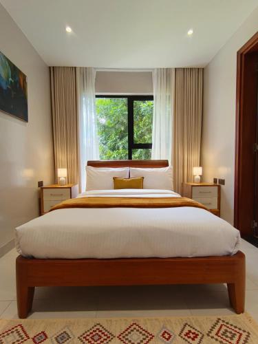 a bedroom with a large bed with a window at The Meru House in Nkubu