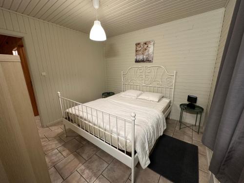 Un dormitorio con una cama blanca en una habitación. en Chalet 't Vraagteken, en Durbuy