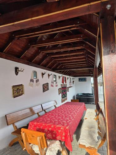 a bedroom with a red table and chairs in a room at Casa Birsan in Jina