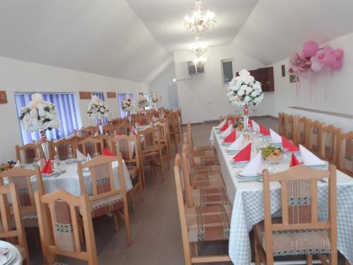 ein Esszimmer mit Tischen und Stühlen mit Blumen in der Unterkunft Casa Birsan in Jina