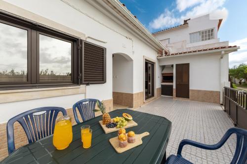 a table with fruit and juice on a patio at Ocean Breeze Baleal in Ferrel