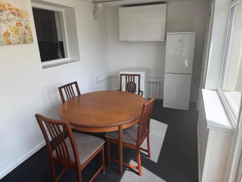 een keuken met een tafel, stoelen en een koelkast bij The Lantern in Bristol