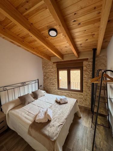 La Campanilla في Los Corrales: غرفة نوم بها سرير وسقف خشبي