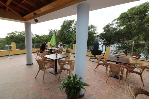two men sitting on a patio with tables and chairs at Vista Mar in Tarrafal