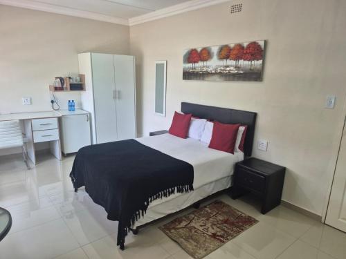 a bedroom with a large bed with red pillows at Ithonsi Guesthouse in Kempton Park
