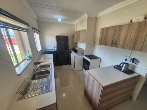 a small kitchen with a sink and a refrigerator at Ithonsi Guesthouse in Kempton Park