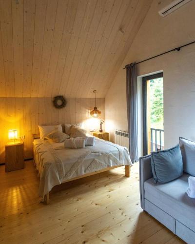 a bedroom with a large bed and a couch at Samatha space in Slavske