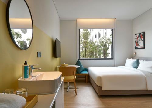 a hotel room with a bed and a sink at GO Hotel Bangkok Suvarnabhumi Airport in Lat Krabang