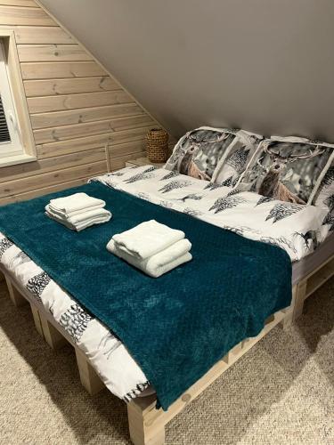 a bed with towels on top of it at Przystanek Leszczyniec w Sudetach z jacuzzi - za dopłatą in Leszczyniec