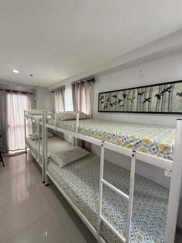 two bunk beds in a room with windows at Penthouse A Near IT Park in Cebu City