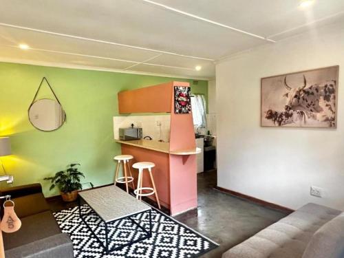 a living room with a kitchen with a counter and stools at Kliprivier Park Tulbagh in Tulbagh