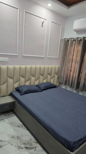 ein Schlafzimmer mit einem Bett mit gepolstertem Kopfteil in der Unterkunft Deoghar BnB in Deoghar