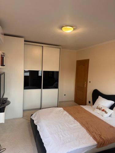 een slaapkamer met een groot bed met witte lakens bij Aquae Lux apartment in Sarajevo