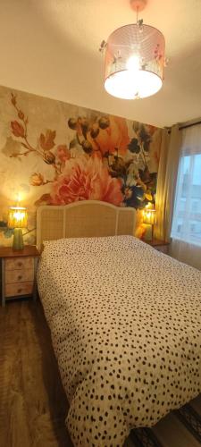a bedroom with a bed with a flower mural on the wall at Cheltenham town centre with parking space in Cheltenham