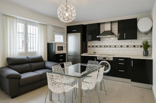 a living room with a glass table and chairs at apartamento sevilla enzo in Seville