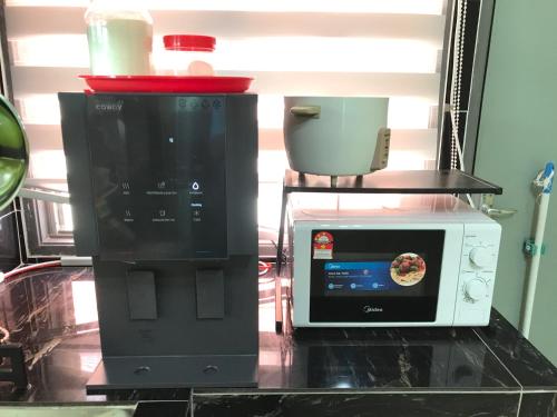 a microwave and a toaster oven on a counter at Fidaiy Homestay in Teronoh