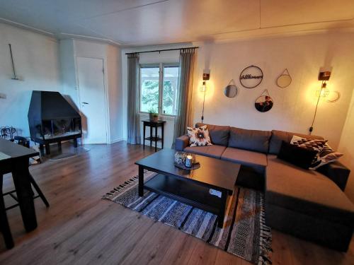 un soggiorno con un divano e un tavolo di Banvaktstuga anno 1905 a Fliseryd