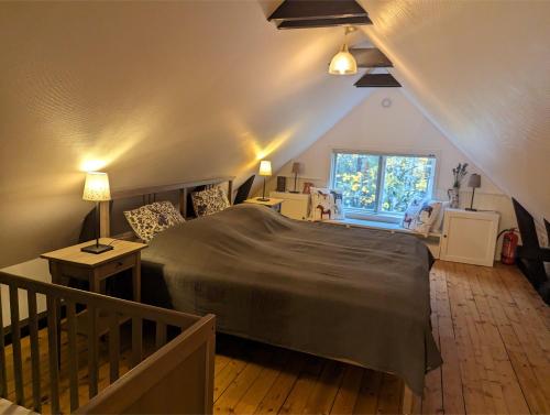 una camera da letto con un letto grande in una mansarda di Banvaktstuga anno 1905 a Fliseryd