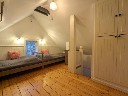 a attic room with two beds and a staircase at Banvaktstuga anno 1905 in Fliseryd