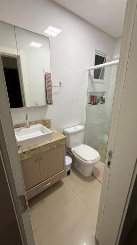 Apto 2 dormitórios Itapema في ايتابيما: حمام مزود بمرحاض ومغسلة ومرآة