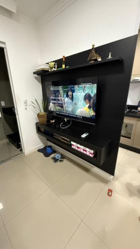 Apto 2 dormitórios Itapema في ايتابيما: تلفزيون بشاشة مسطحة في مركز ترفيه أسود