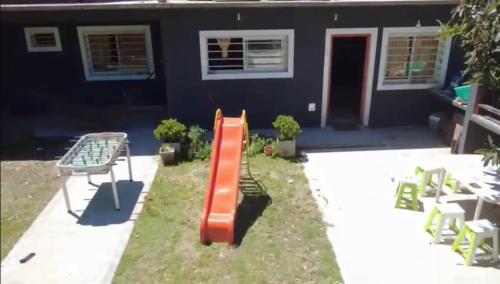 un parco giochi con scivolo rosso di fronte a una casa di La Felicidad a Ostende