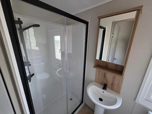 een badkamer met een douche, een toilet en een wastafel bij Luxury 3 bed sleeps 8 caravan with sea view in Exmouth