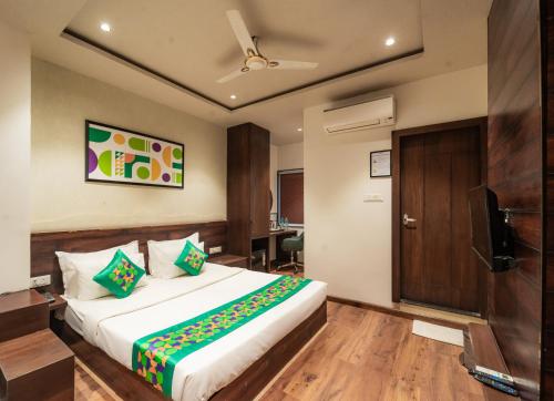 une chambre d'hôtel avec un lit et une télévision dans l'établissement Treebo Awadhvue, à Indore